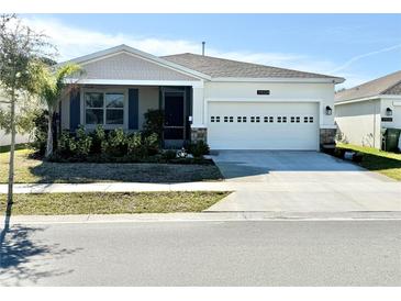 Charming single-story home featuring a two-car garage, screened entry, and well-maintained landscaping at 34004 Sky Blossom Cir, Leesburg, FL 34788