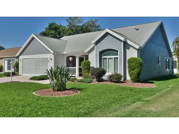 Charming home featuring neutral siding, brick accents, well-maintained landscaping, and an attached two-car garage at 631 San Pedro Dr, The Villages, FL 32159