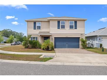 Charming two-story home with a well-manicured lawn, blue shutters, and a two-car garage at 6401 Domenico Ct, Groveland, FL 34736