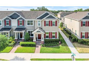 Beautiful townhome with well-maintained landscaping, red shutters, and a cozy front porch at 644 Orange Belt Loop, Winter Garden, FL 34787