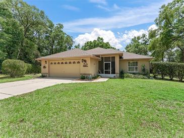 Charming single-story home with a well-manicured lawn and a two-car garage at 7260 Se 124Th Ln, Belleview, FL 34420