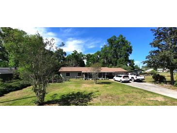 Charming single-story home with a well-maintained lawn, mature trees, and a private driveway, offering a serene and welcoming atmosphere at 1431 Ne 53Rd St, Ocala, FL 34479