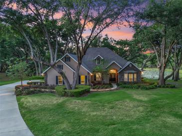 Stunning home with mature trees, lush lawn, beautiful landscaping and stone accents at 2010 Otters Pond Rd, Fruitland Park, FL 34731
