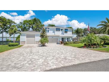 Beautiful two-story home with a long brick driveway and a three-car garage at 26516 Savage Cir, Howey In The Hills, FL 34737