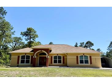 Charming home boasts a well-manicured lawn, beautiful roof, and a welcoming double-door entrance at 30554 Quince Ave, Eustis, FL 32736