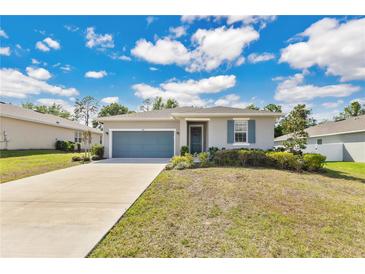 Charming single-story home with a well-maintained lawn, complemented by a two-car garage and vibrant green shrubbery at 31799 Broadwater Ave, Leesburg, FL 34748