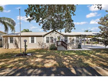 Charming single-story home featuring a metal roof, covered parking, and landscaped front yard at 37945 Monticello St, Leesburg, FL 34788