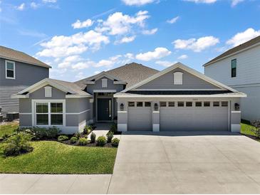 Charming single-story home with a manicured lawn and a spacious three-car garage at 7669 Chastain Cir, Middleton, FL 34762