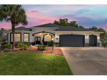 Charming single-story home featuring a well-manicured lawn and a two-car garage at 8715 Se 176Th Lowndes Pl, The Villages, FL 32162