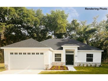 Charming single-story home featuring an attached two-car garage and a well-manicured front yard at 8742 Se 158Th Pl, Summerfield, FL 34491