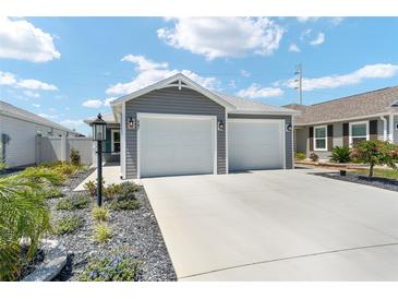 Charming home featuring a two-car garage, landscaped yard with rock detail and tasteful exterior lighting at 947 Couture St, The Villages, FL 32163