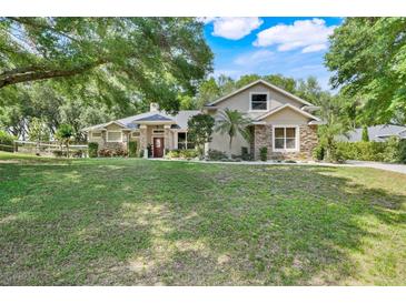 Charming single-Gathering home with stone accents, mature landscaping, and a well-manicured lawn at 10851 Lantana Crst, Clermont, FL 34711
