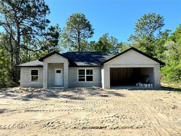 Unfinished single Gathering house has an attached garage with a white front door at 12 Guava Terrace Radl, Ocklawaha, FL 32179