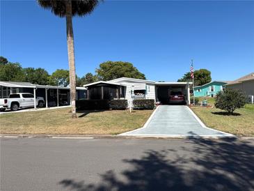 Charming single-story home featuring a well-kept lawn and a shaded carport on a sunny day at 1616 Lauren Ln, Lady Lake, FL 32159