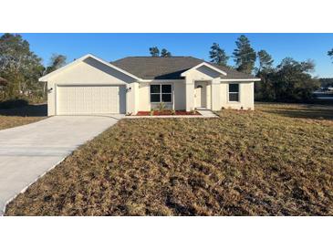 Charming single-story home with attached garage, manicured lawn and newly installed flower bed at 16487 Sw 55Th, Ocala, FL 34473