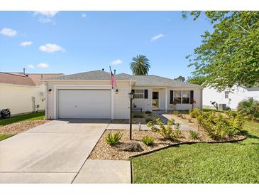 Charming single-story home featuring a well-manicured lawn and an attached one car garage at 17076 Se 96Th Chapelwood Cir, The Villages, FL 32162