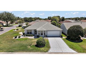 Charming single-story home featuring a well-manicured lawn and a decorative driveway at 1902 Del Norte Dr, Lady Lake, FL 32159
