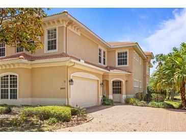 Charming two-story home with a neutral color scheme, a tile roof, brick driveway, and a manicured front yard at 26207 Avenida Las Colinas # 26207, Howey In The Hills, FL 34737