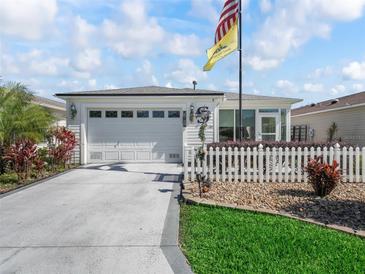 Charming home with a well-manicured lawn, inviting curb appeal, and an attached two-car garage at 2729 Craven Way, The Villages, FL 32162