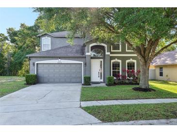 Charming two-story home featuring a well-manicured lawn, gray siding and a two car garage at 30236 Pga Dr, Sorrento, FL 32776