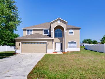 Inviting two-story home showcasing a well-manicured lawn and a two-car garage at 307 Big Black Ln, Poinciana, FL 34759