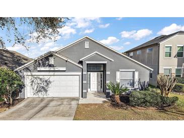 Charming single Gathering home featuring well-maintained landscaping and an attached two-car garage at 308 Anorak St, Groveland, FL 34736