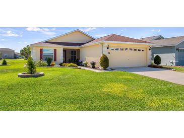 Charming home with a well-manicured lawn and colorful flower beds at 4671 Spring Grove Ln, Leesburg, FL 34748