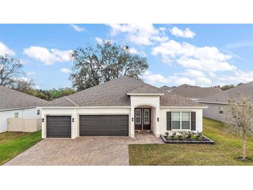 Charming one-story home with a three-car garage, manicured lawn, and a welcoming front entrance at 488 Avila Pl, Howey In The Hills, FL 34737