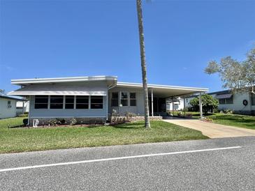 Charming single story home featuring a carport and manicured front lawn at 504 Hawthorne Blvd, Leesburg, FL 34748