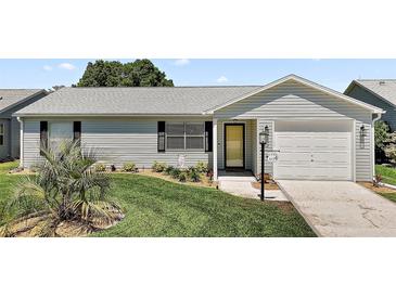 Charming home featuring a well-manicured lawn, lush landscaping, and a welcoming front entrance at 517 San Pedro Dr, Lady Lake, FL 32159