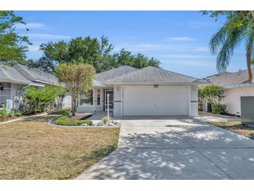 Charming single Gathering home with a well-manicured lawn and two car garage at 5614 King James Ave, Leesburg, FL 34748