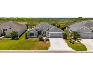 Beautiful one story home with a manicured lawn, long driveway and charming front porch at 1016 Pickering Path, The Villages, FL 32163