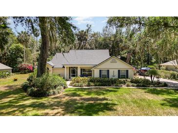 Charming single-story home featuring mature landscaping and a well-maintained front yard, with a screened in porch at 16730 Beauclaire Ct, Tavares, FL 32778