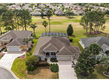 Beautiful aerial view of a well-maintained home featuring a screened pool and lush green landscaping at 2706 Radbourne Way, The Villages, FL 32162