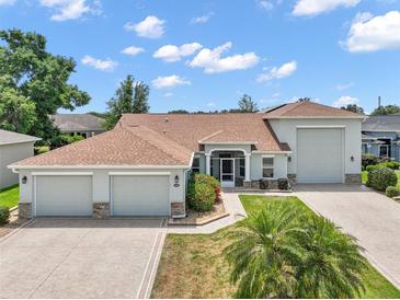 Attractive single-Gathering home featuring a three-car garage and a meticulously landscaped front yard at 4320 Heritage Trl, Leesburg, FL 34748