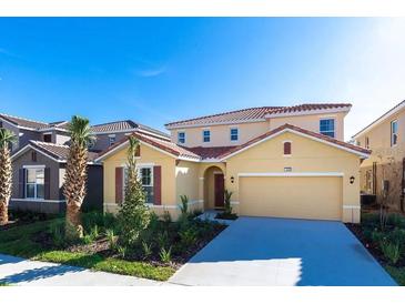 Inviting two-story home featuring a red tile roof and attached two car garage at 8024 Oak Shadow Ct, Davenport, FL 33837