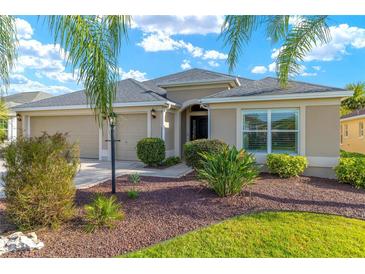 Beautiful single story home featuring a well-maintained lawn and a two-car garage at 857 Enisgrove Way, The Villages, FL 32163