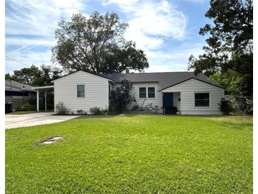 Charming single-story home with a well-manicured lawn and a covered carport to the side at 1414 Margate Ave, Orlando, FL 32803