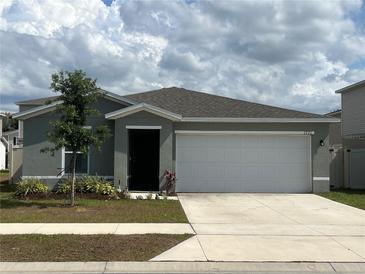 Charming single-Gathering home featuring a two-car garage and well-maintained front yard at 1721 Nebraska Loop, Sumterville, FL 33585