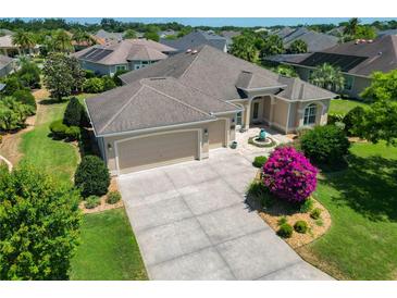 Lovely single-story home featuring a well-manicured lawn, neutral paint scheme, and a spacious driveway and attached garage at 1842 Lake Ridge Dr, The Villages, FL 32162