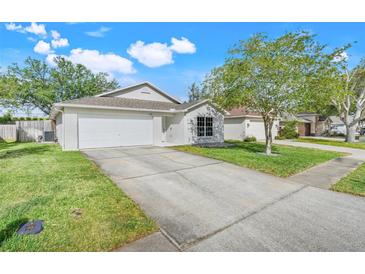 Charming single-story home featuring a well-manicured lawn and two car garage at 2136 Fish Eagle St, Clermont, FL 34714