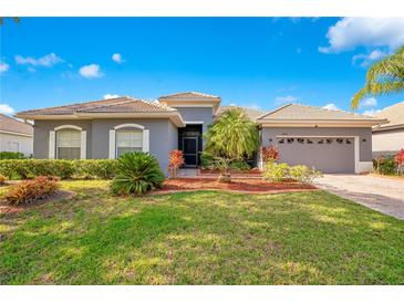Charming single-story home with well-manicured lawn and tiled roof under blue skies at 2641 Meadow View Ct, Kissimmee, FL 34746