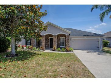 Charming home featuring stone accents, a well-manicured lawn, and a two-car garage at 31920 Parkdale Dr, Leesburg, FL 34748