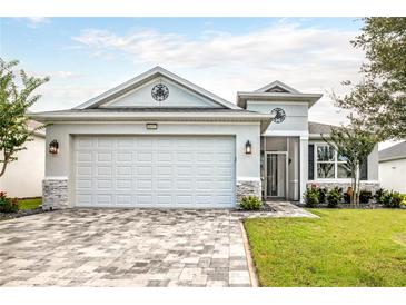 Charming single-story home with a paver driveway, two-car garage, and well-maintained landscaping at 8492 Hartford Way, Mount Dora, FL 32757