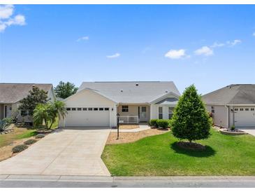 Charming one-story home with well-manicured lawn, concrete driveway, and attached two-car garage at 951 Chapman Loop, The Villages, FL 32162