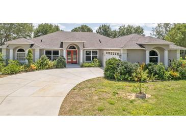 Charming single-story home featuring a circular driveway and well-manicured landscaping at 987 Princeton Dr, Clermont, FL 34711