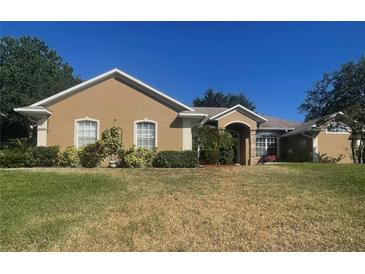Inviting single-story home with stucco exterior, manicured landscaping, and a well-maintained front lawn at 11301 Via Mari Cae Ct, Clermont, FL 34711