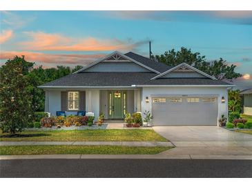 Charming single-story home featuring a well-manicured lawn, lovely landscaping, and a two-car garage at 16211 Oak Breeze Ct, Clermont, FL 34711