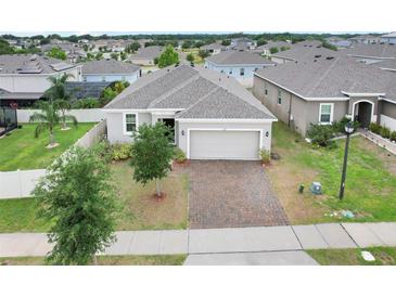 Charming single-story home with a well-maintained lawn and a brick-paved driveway at 169 Jensen Dr, Groveland, FL 34736