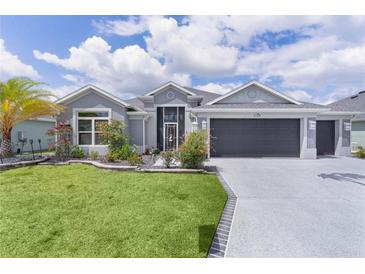 Beautiful single Gathering home with a well manicured lawn and landscaping with a two car garage at 2129 Landrea Loop, The Villages, FL 32163